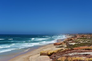 Una playa cerca, arena blanca, sombrillas, toallas de playa