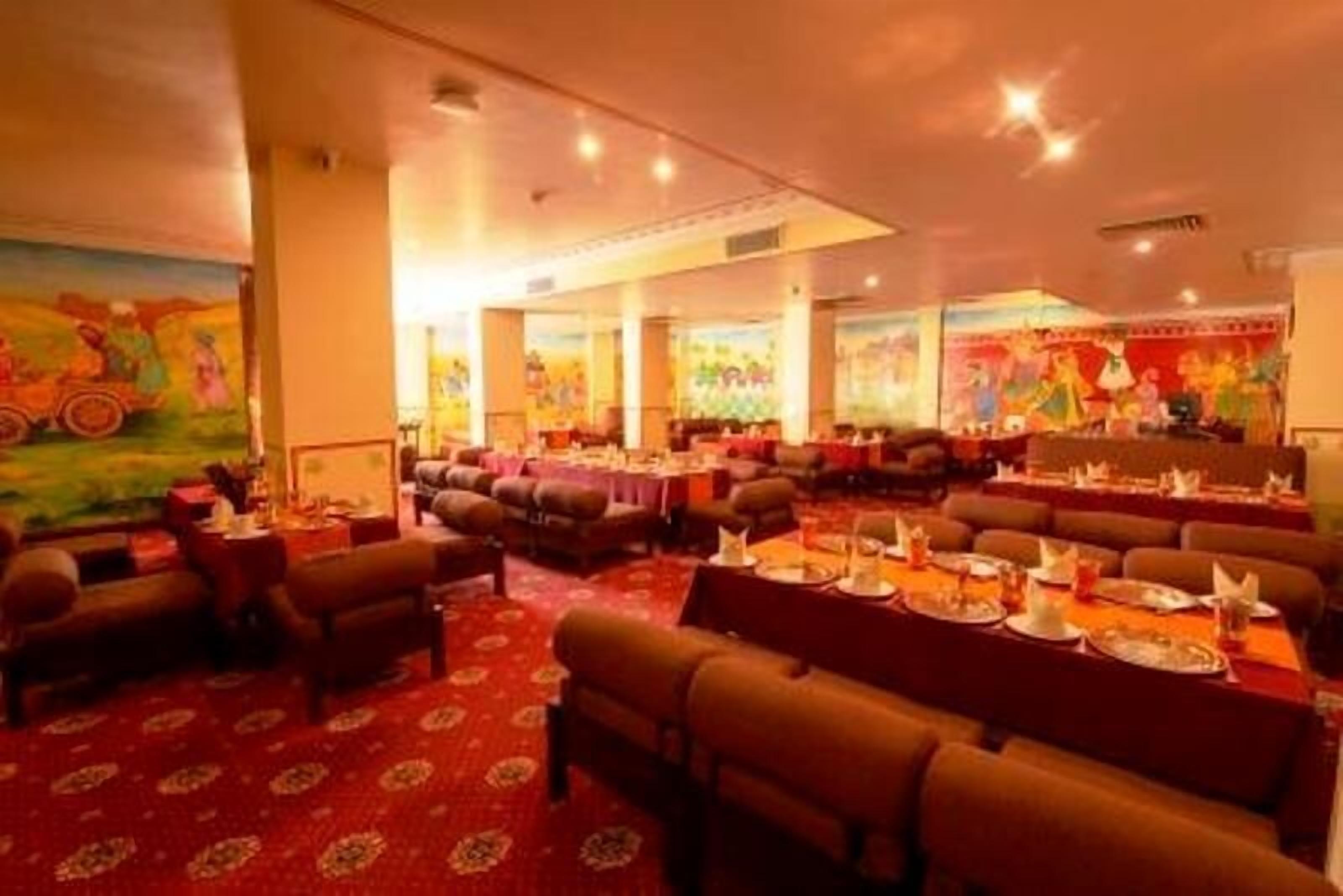 Ein Restaurant mit mehreren Essbereichen, jeweils mit für Gäste gedeckten Tischen.