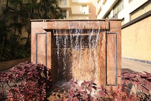 A water feature with a sign that reads "DENTAL". - Dynasty Hotel (Guwahati)