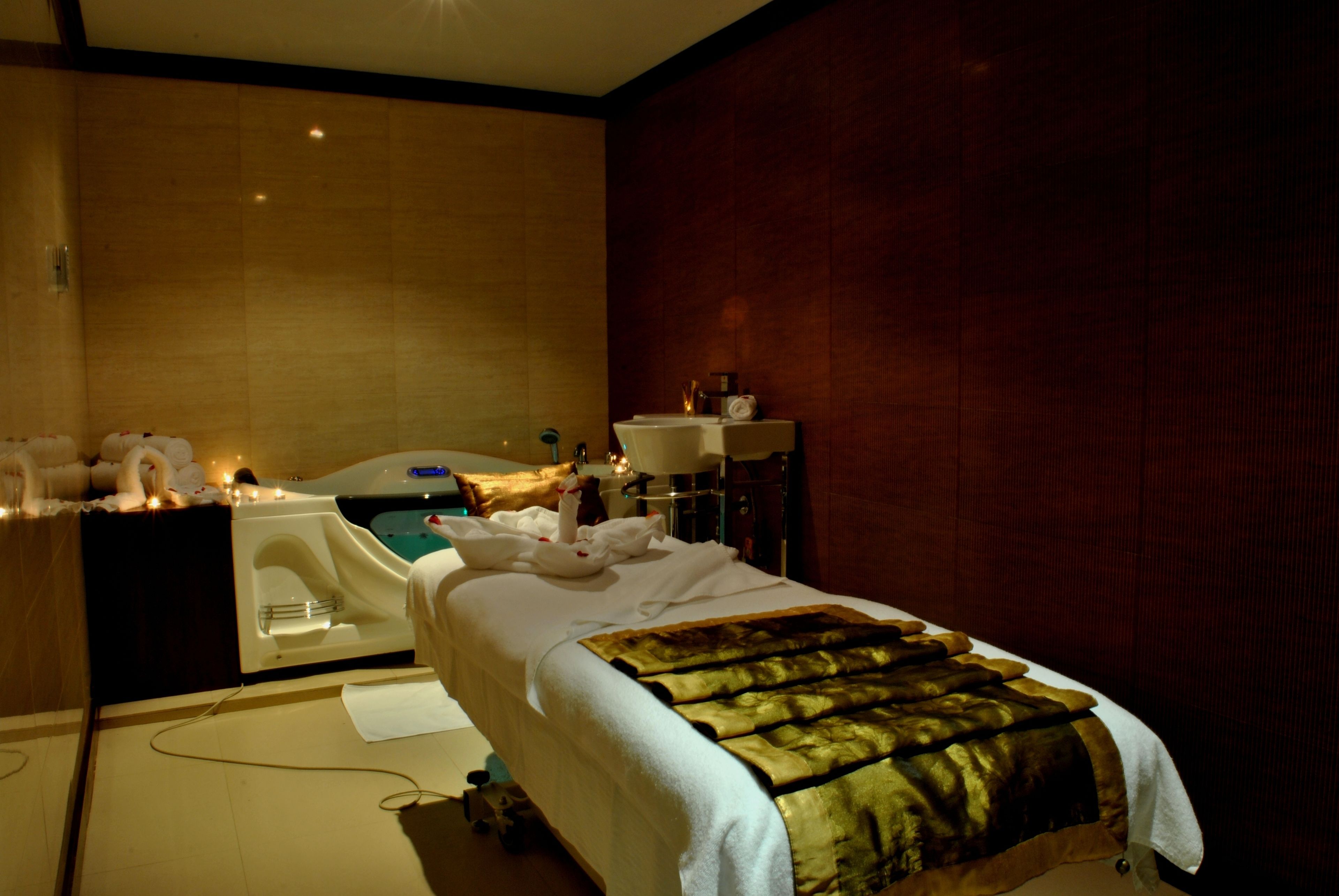Een hotelkamer met een bed, een badkuip en een wastafel.