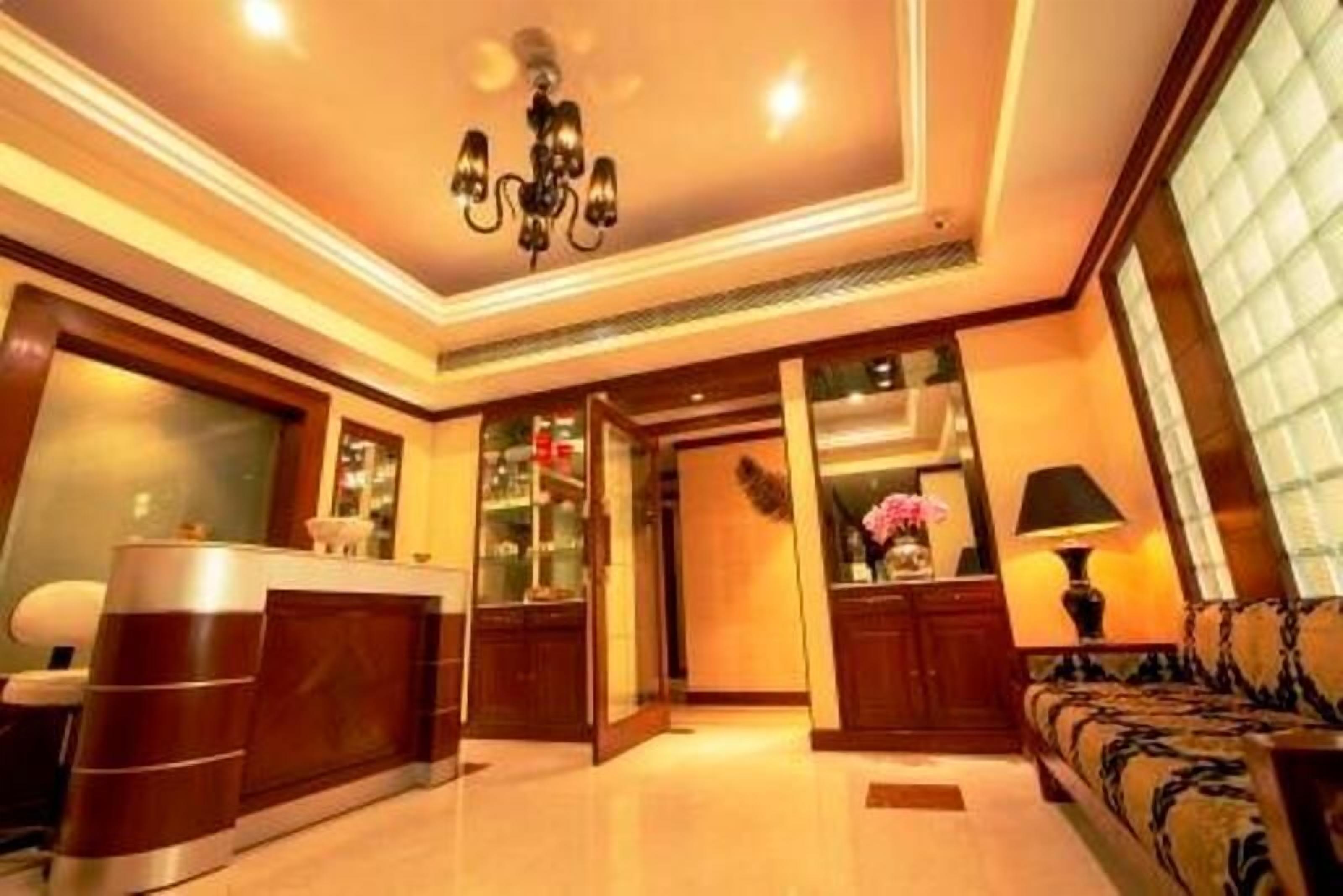 Un vestíbul d'hotel ben il·luminat amb una recepció, zona de seients i un penjador.