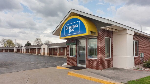 A Rodeway Inn with a brick exterior and a blue and yellow sign.