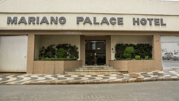 El exterior del Hotel Palacio Mariano, con un acceso de baldosas y un camino de entrada portonado.