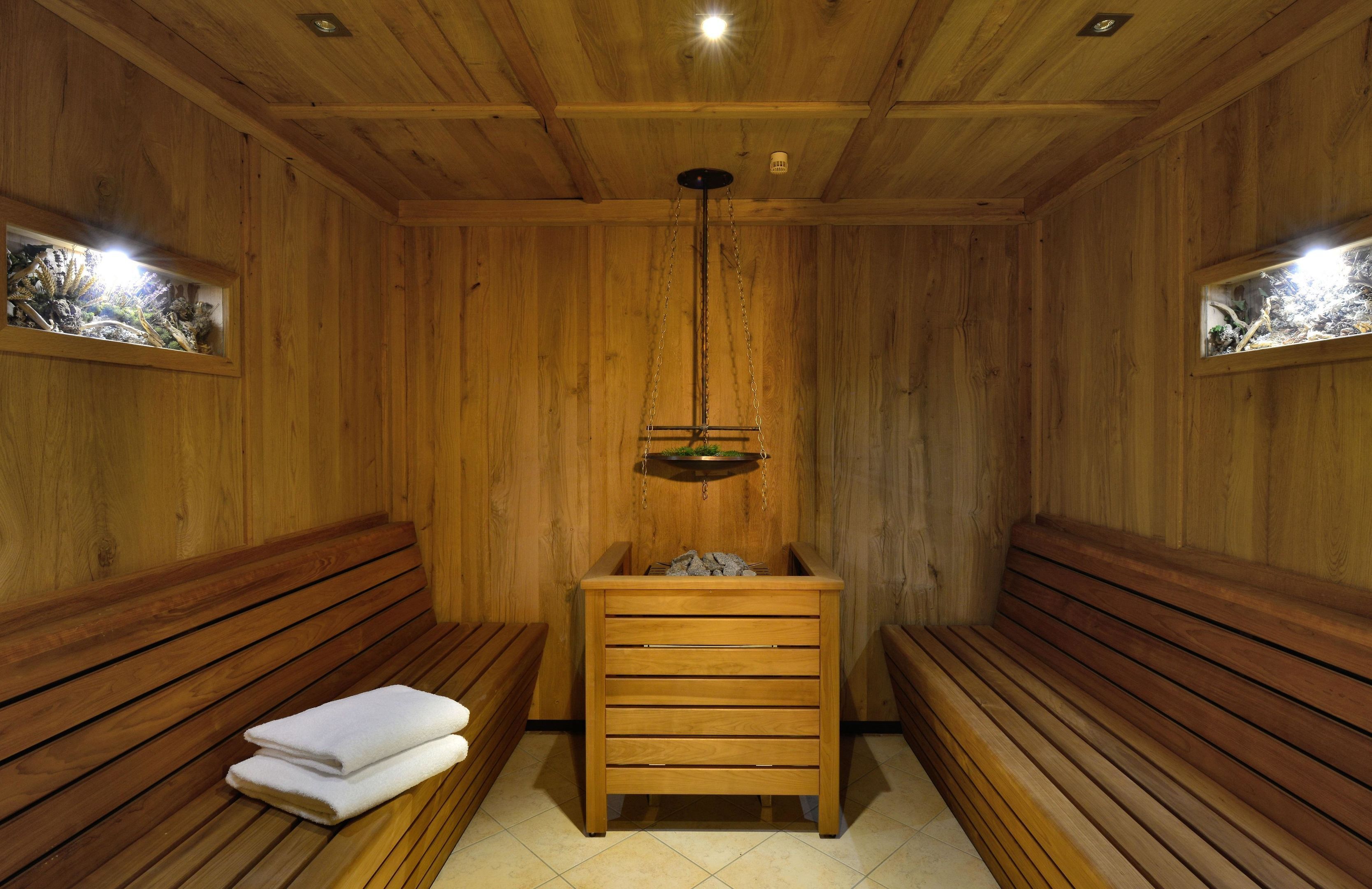 Eine Holzsauna mit Bänken und einer Sitzbank mit Handtüchern.