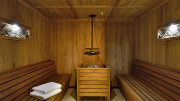 Eine Holzsauna mit Bänken und einer Sitzbank mit Handtüchern.