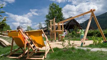 Children can play on the swing set and slide in the grassy area.