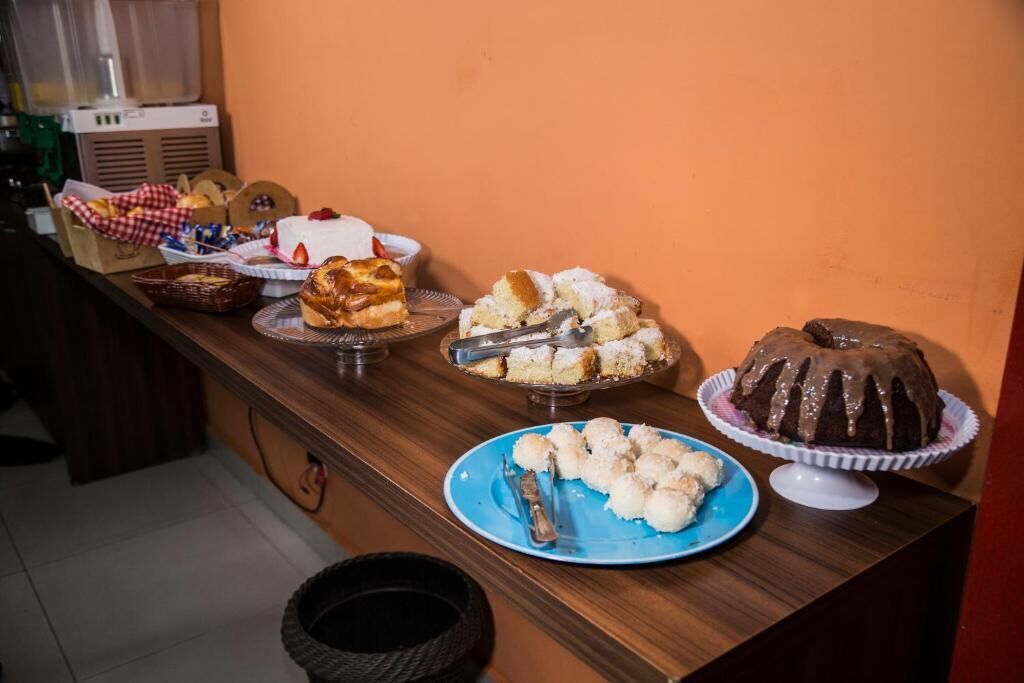Una mesa de bufé con diversos postres y un pastel sobre un pedestal.