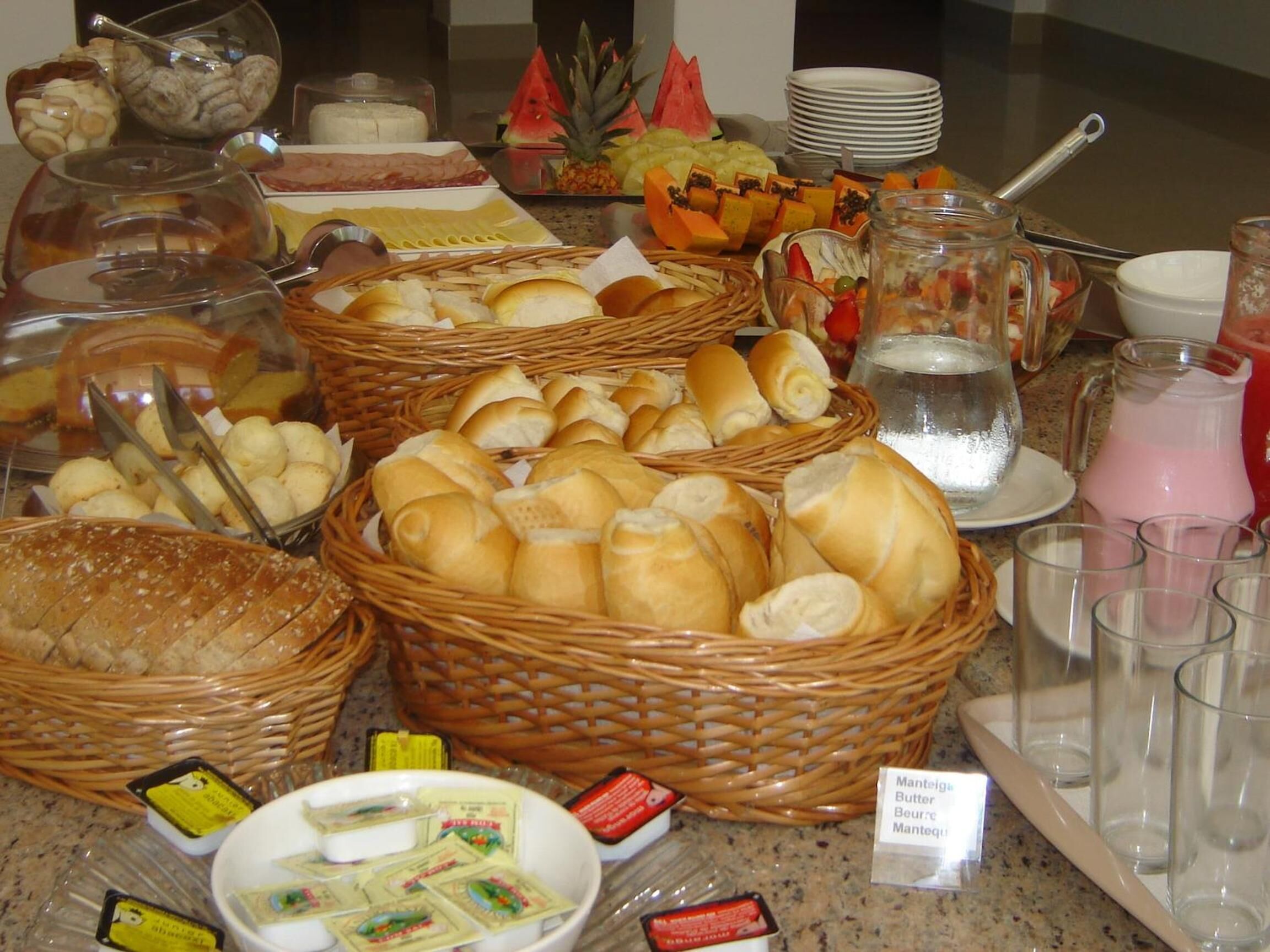 A buffet table with various food items and condiments.