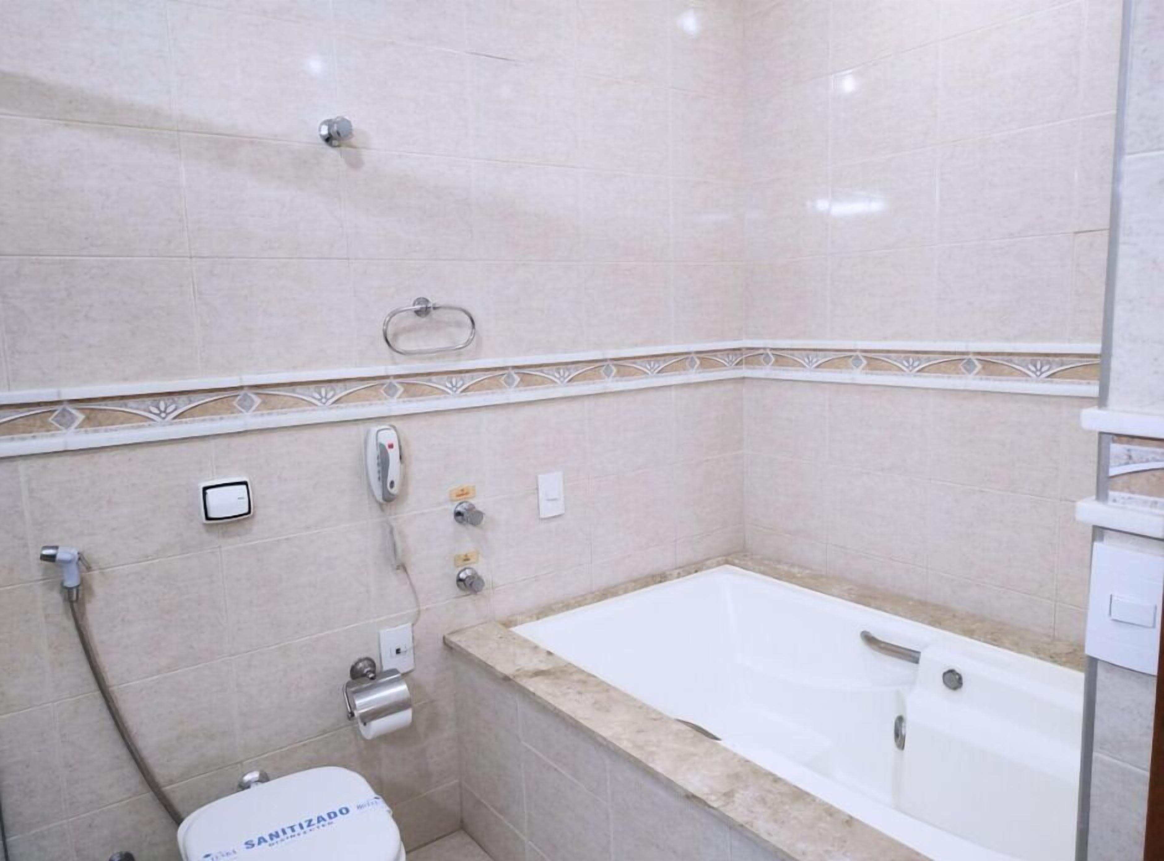 Un baño con bañera, inodoro y ducha.