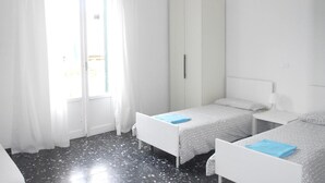 A room with two beds, a wardrobe, and a window with curtains. - La Pergola (Vezzano Ligure)