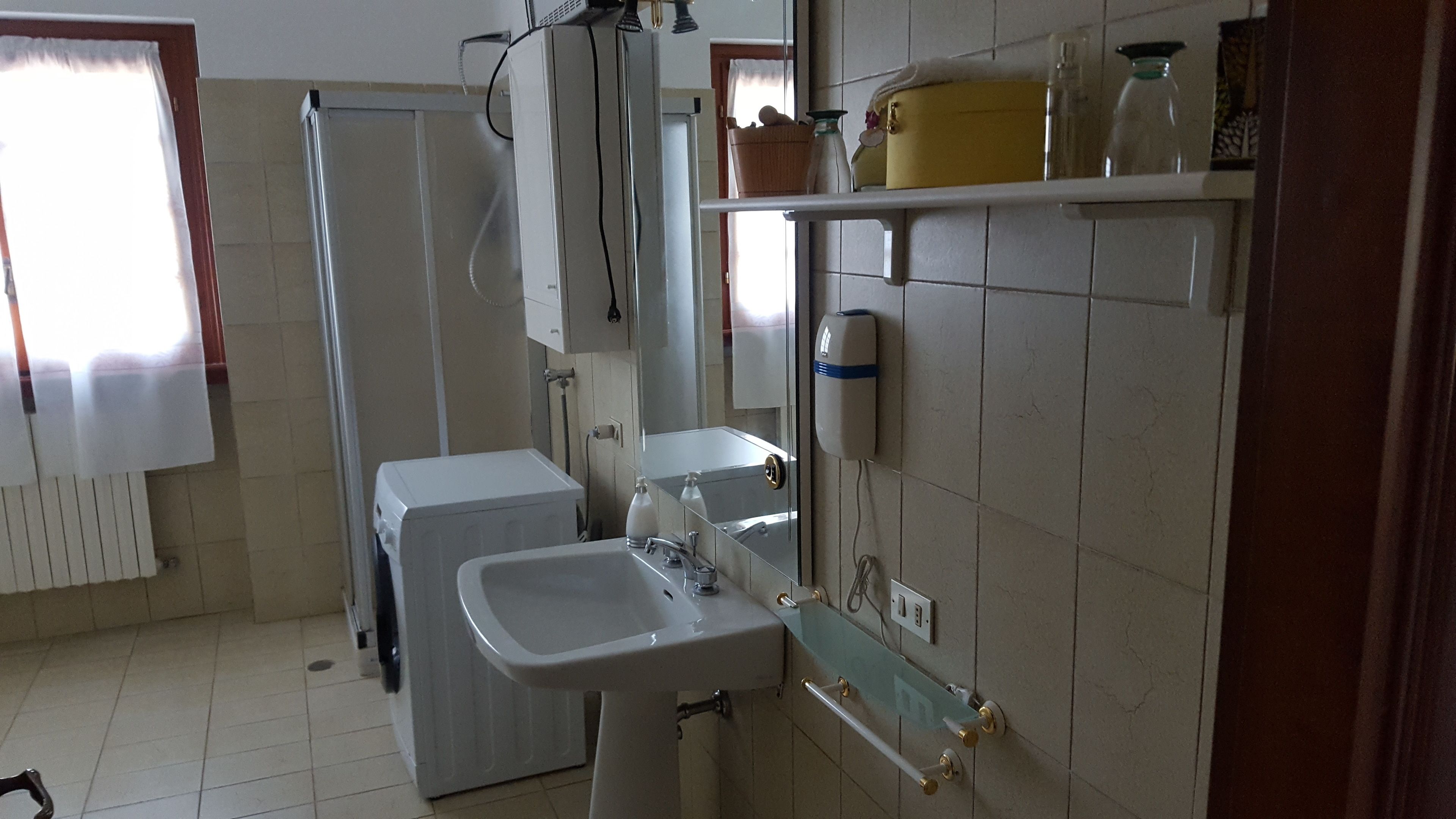 A bathroom with a sink, mirror, and towel rack.
