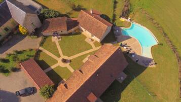 Una piscina techada, una piscina al aire libre, sombrillas