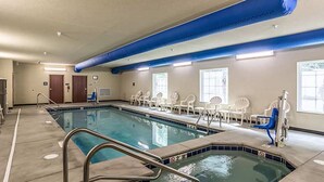 Ein Swimmingpool mit Whirlpool, Liegestühlen und einer Tür.