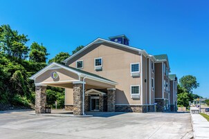 A hotel with a beige exterior, stone pillars, and a covered entrance.