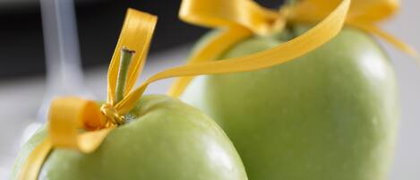 Two green apples tied with yellow ribbons.
