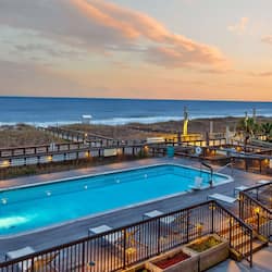 Relax by the ocean-view pool surrounded by lounge chairs and lush greenery.