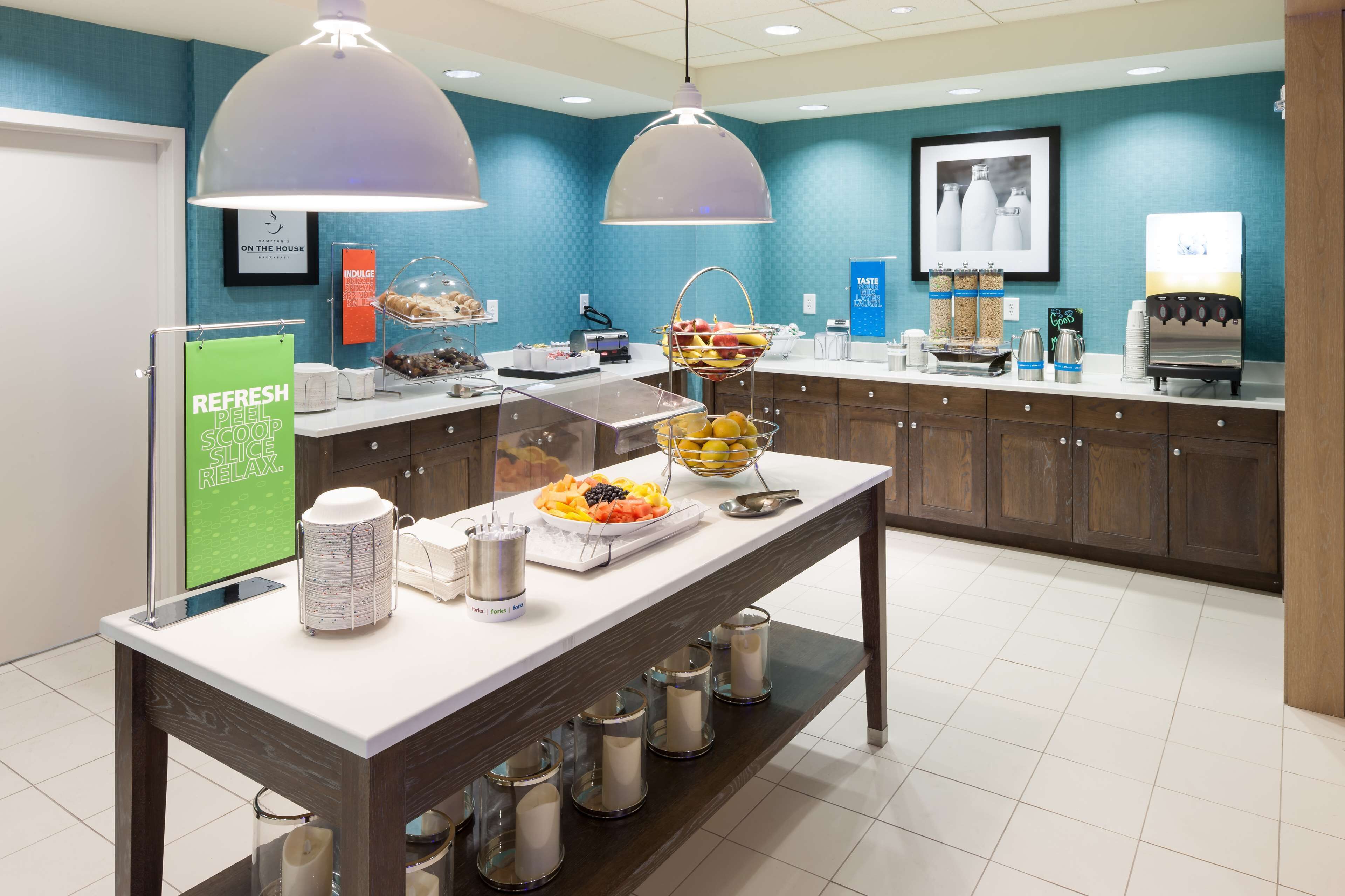 A buffet area with a variety of food items, a coffee station, and a sign promoting a skin care product.