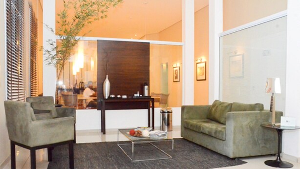 Un salon moderne comprenant un canapé, un fauteuil, une table basse et une petite table d’appoint.