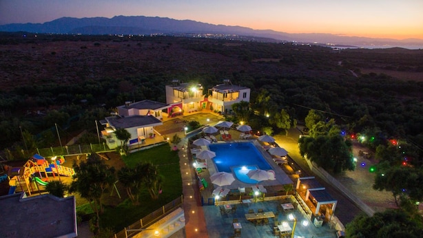 An aerial view of a resort with a swimming pool, outdoor seating, and a children's play area. - Paradisio Baby and Kinder Hotel (Chania)