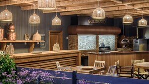 A rustic interior with wooden beams, a bar area, and hanging wicker lights. - Paradisio Baby and Kinder Hotel (Chania)