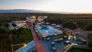A resort with a large swimming pool, outdoor seating, and a view of the mountains. - Paradisio Baby and Kinder Hotel (Chania)