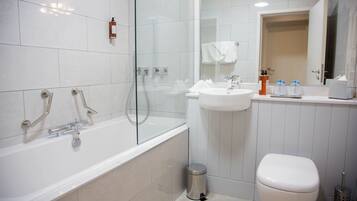 A modern bathroom with a glass-enclosed shower, a white sink, and a toilet.