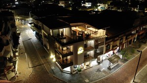 Ein mehrstöckiges Hotel mit Restaurant im Erdgeschoss und einer sichtbaren Treppe zu den oberen Etagen.