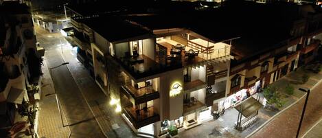 A multi-story hotel with a ground floor restaurant and a visible staircase leading to the upper floors.