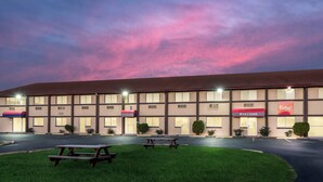 A hotel with a flat facade, multiple windows, and a red awning with the word 'WELCOME'. - Red Roof Inn & Suites Wapakoneta (Wapakoneta)