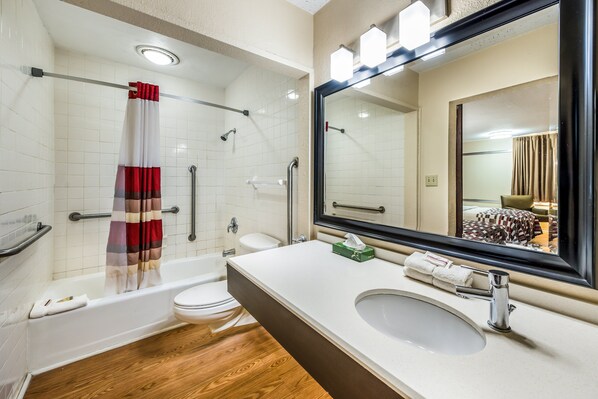 A modern bathroom with a bathtub, toilet, and sink. - Red Roof Inn & Suites Wapakoneta (Wapakoneta)