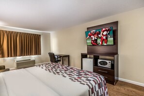 A hotel room with a bed, a desk, a chair, a television, and a microwave. - Red Roof Inn & Suites Wapakoneta (Wapakoneta)