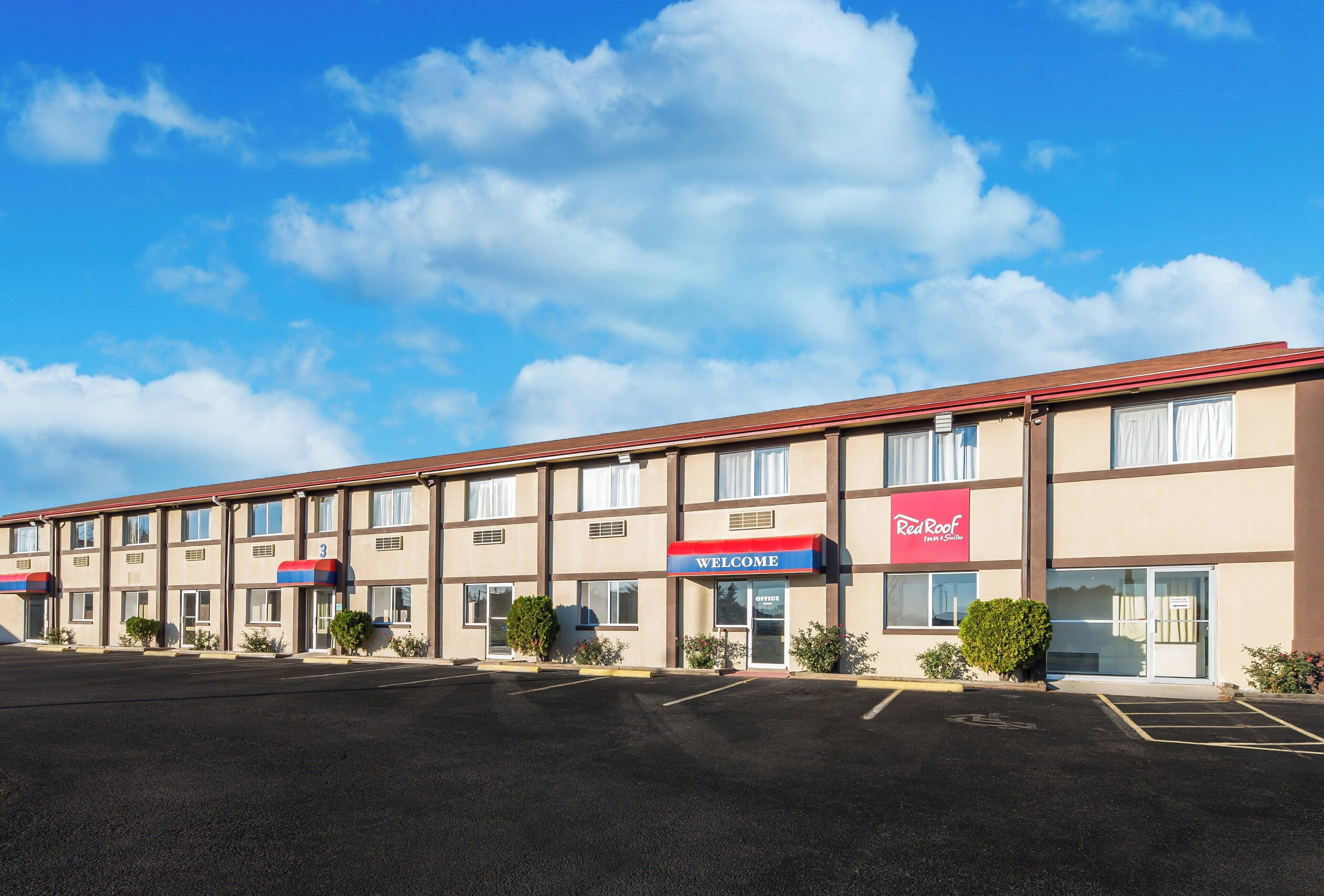A Red Roof Inn & Suites with a parking lot in front.