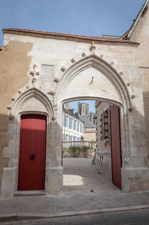 Un edificio de piedra con dos puertas rojas y un arco gótico.