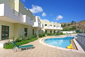 Una piscina al aire libre, sombrillas, tumbonas