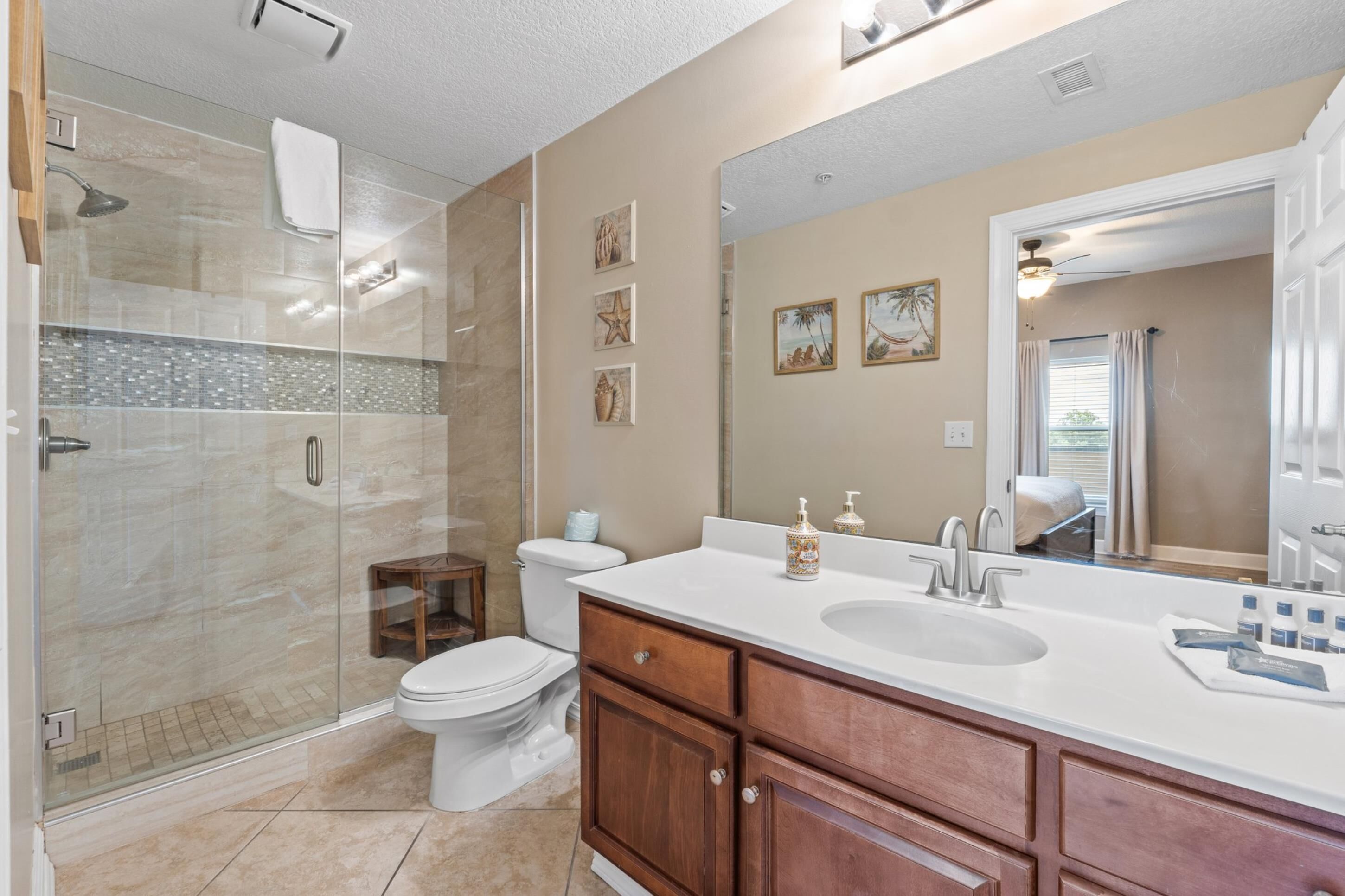 Une salle de bain moderne avec une douche à parois de verre, un meuble-lavabo à deux vasques et un grand miroir.