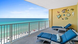 A balcony with wicker lounge chairs and a view of the beach. - Tropic Winds by Panhandle Getaways (Panama City Beach)