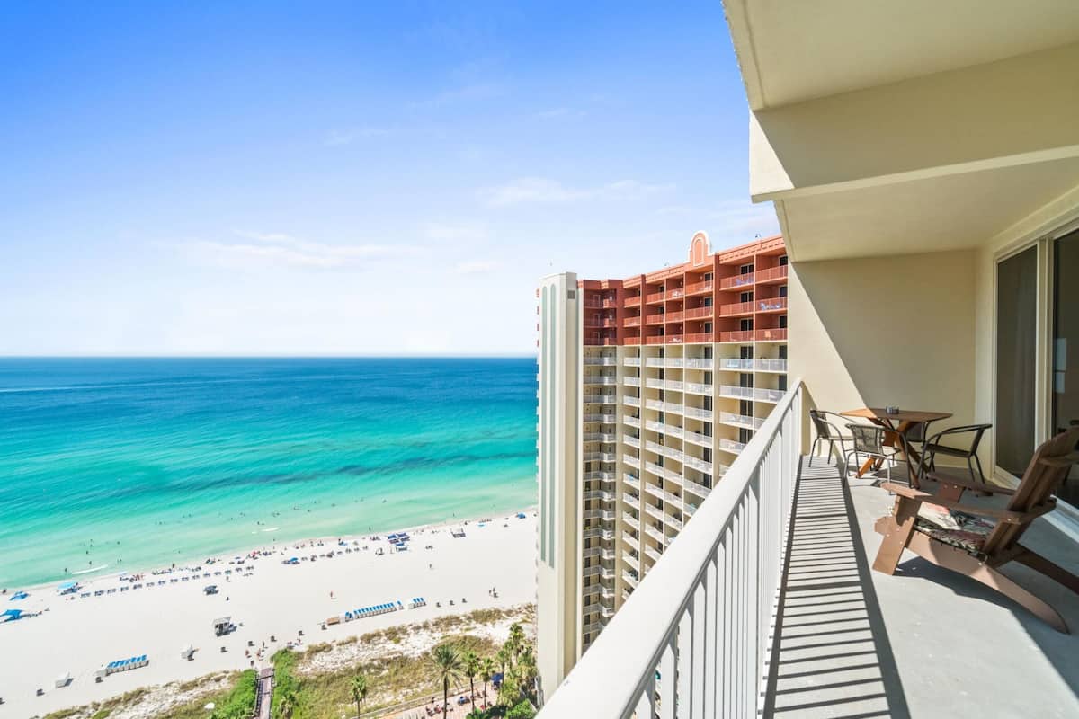 A balcony with a view of a beach and ocean.