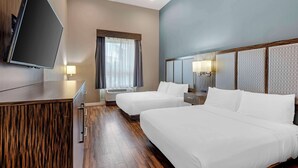 A hotel room with two beds, a flat-screen TV mounted on a wooden cabinet, a window with curtains, and a wall-mounted lamp. - Best Western Plus Pflugerville (Pflugerville)