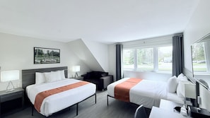 A hotel room with two beds, a desk, a chair, a window with curtains, and a painting on the wall.