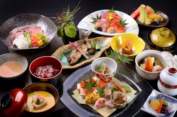 A variety of Japanese dishes, including sushi and sashimi, arranged on a table.