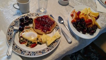 Un desayuno con platos de comida, utensilios y una taza.