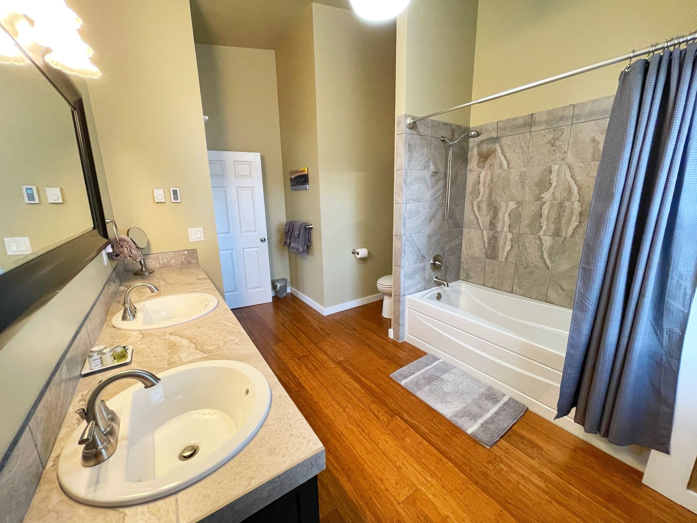 A bathroom with two sinks, a bathtub, and a shower.