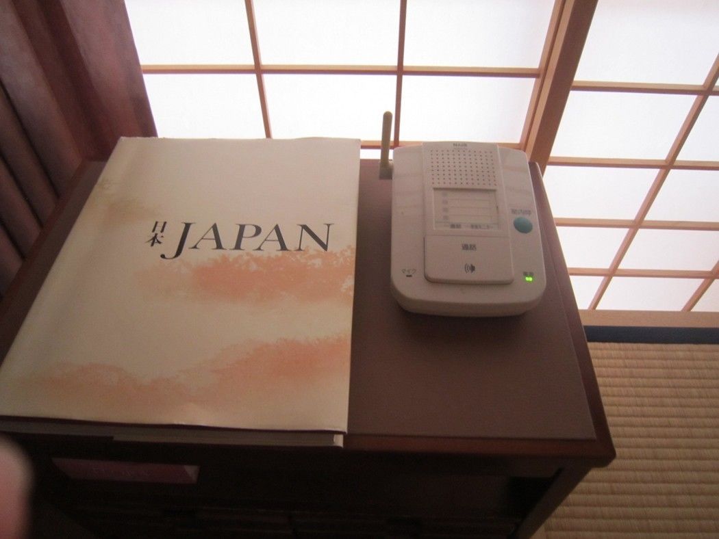 A book titled "Japan" and a portable device on a wooden table.