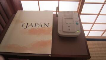 A book titled "Japan" and a portable device on a wooden table.