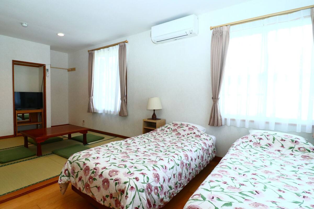 Ein Hotelzimmer mit Bett, Fernseher, Schreibtisch und Fenster.