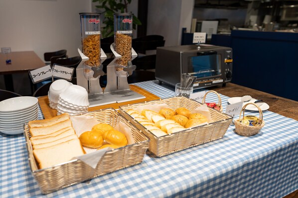 A buffet table with various food items and condiments.