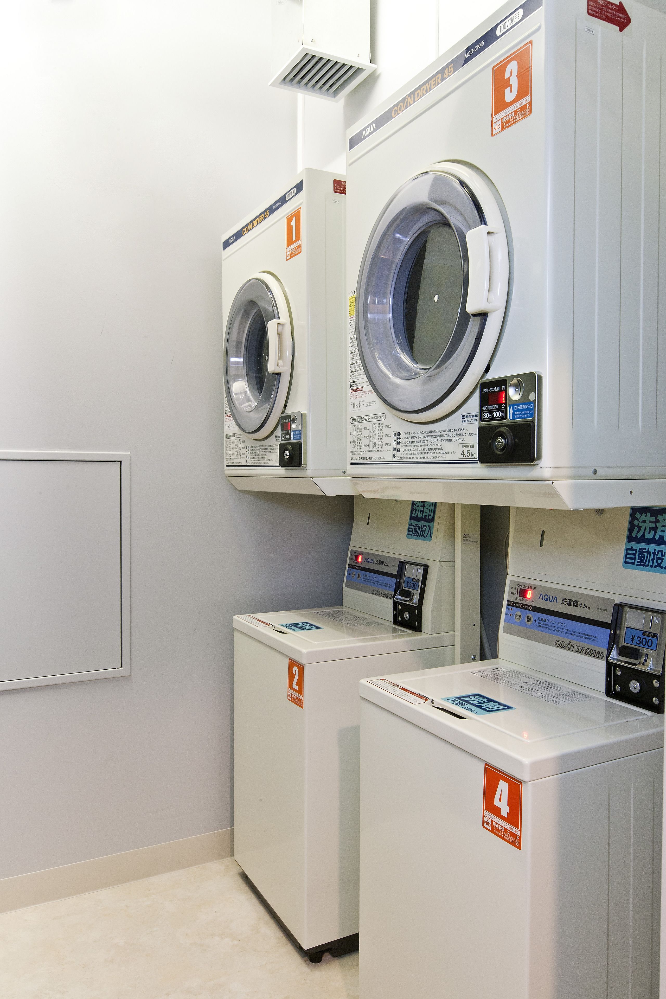 A laundry facility with four washing machines, each marked with a number from 1 to 4.