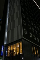 A modern building with a prominent vertical light feature and large windows.