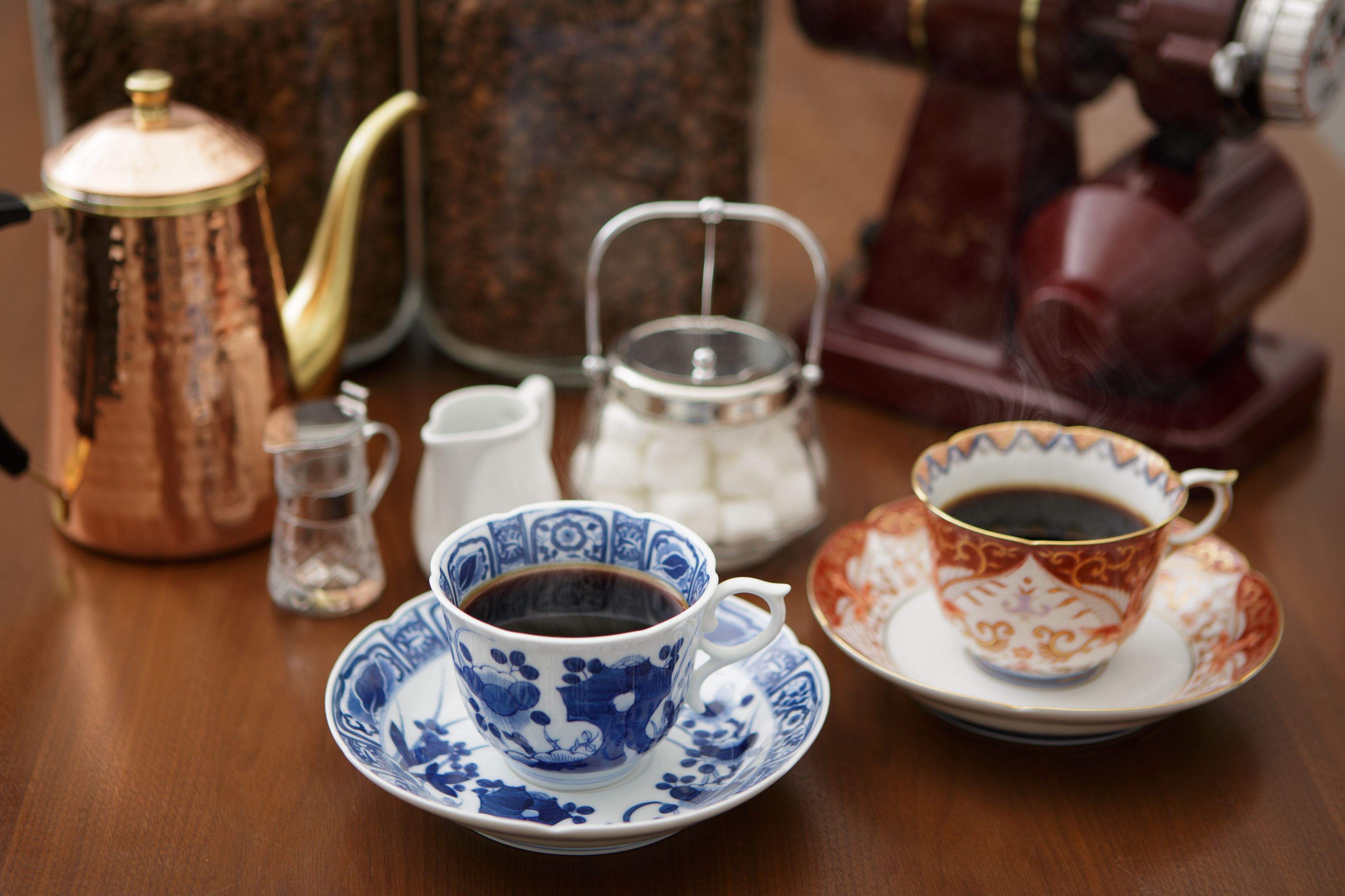 A table with a coffee pot, teapot, and cups.