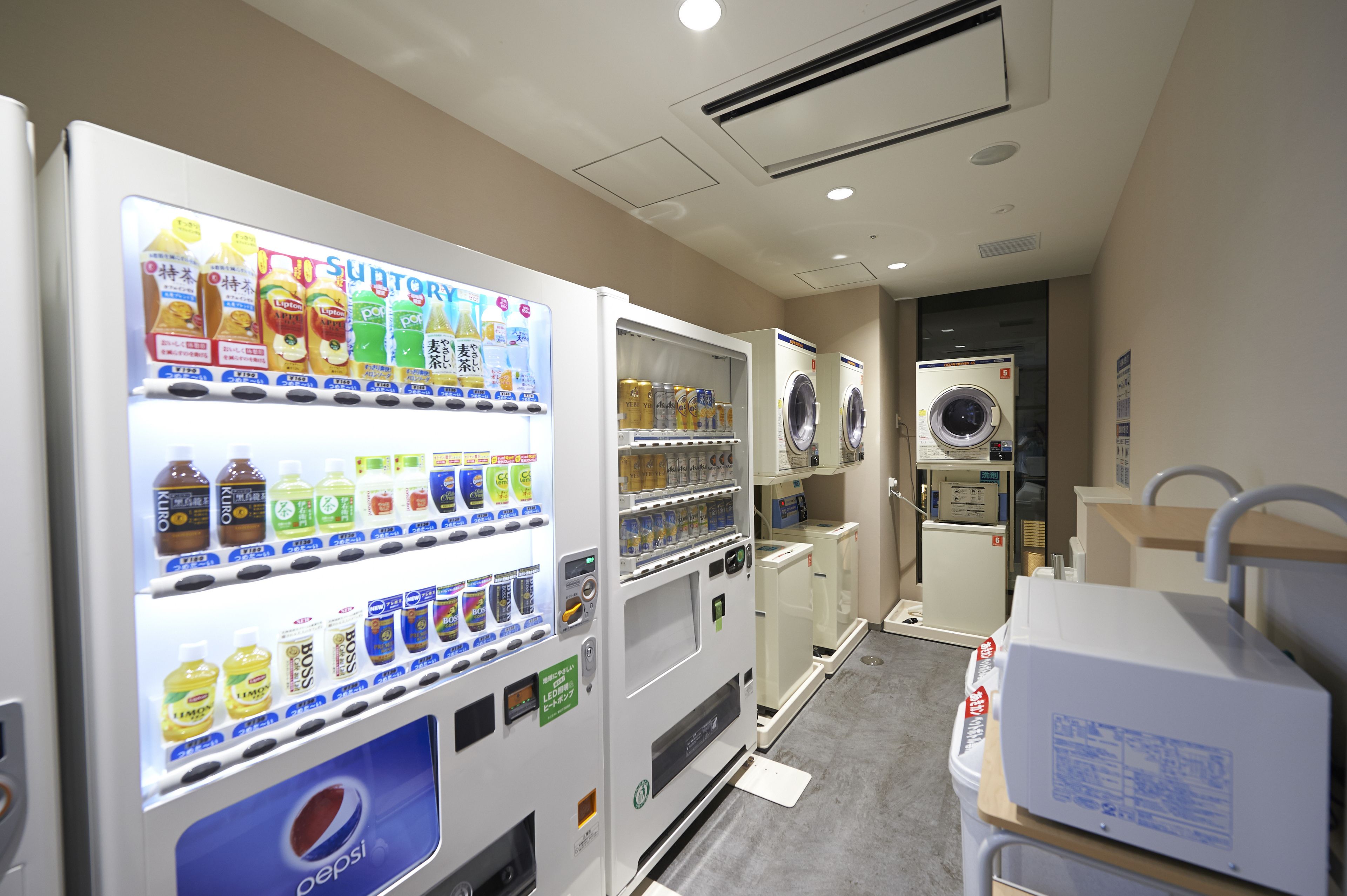 A vending machine area with various drink options and a washing machine.